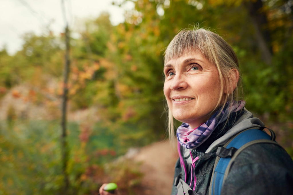 older white woman with bangs wearing outdoor gear smiling while outside